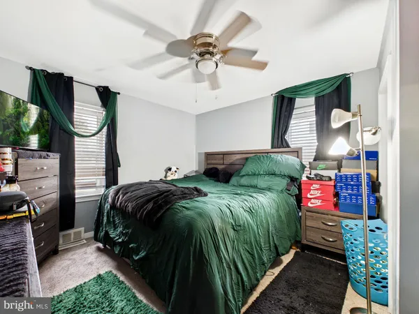 a bedroom with bed and a mirror on the dresser
