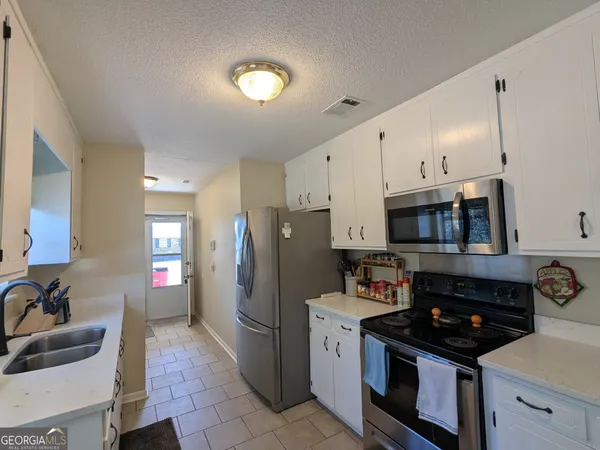 a kitchen with stainless steel appliances granite countertop a stove a refrigerator and a sink