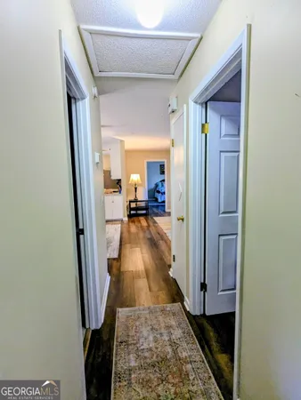 a view of a hallway with wooden floor and furniture