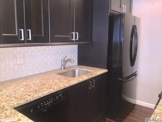 a kitchen with granite countertop stainless steel appliances a sink stove and refrigerator