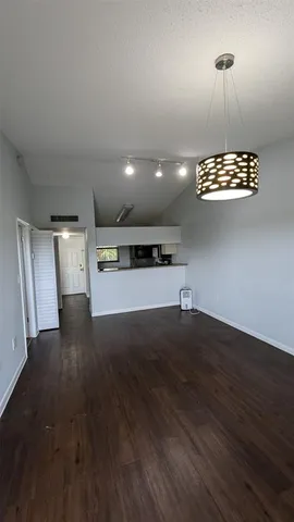 an empty room with wooden floor a ceiling fan and window