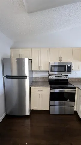 a kitchen with wooden floors and stainless steel appliances