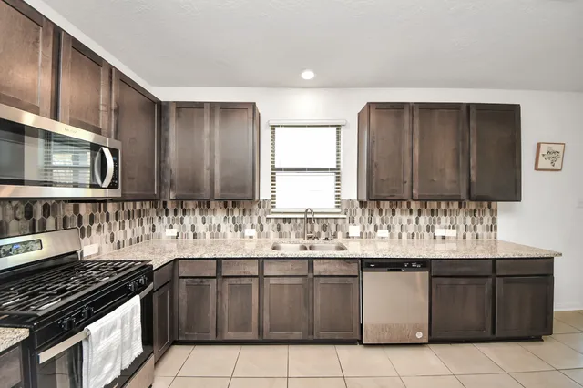 a large kitchen with a sink and cabinets