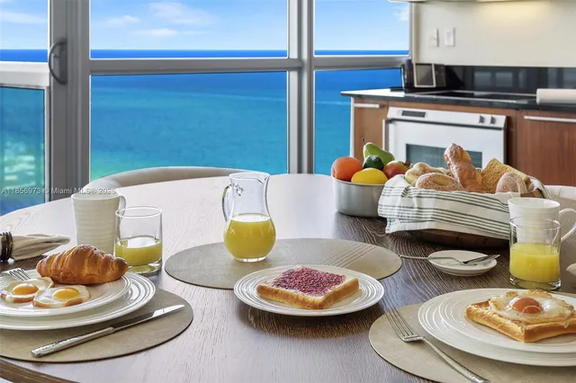 a living room with furniture kitchen view and a large window