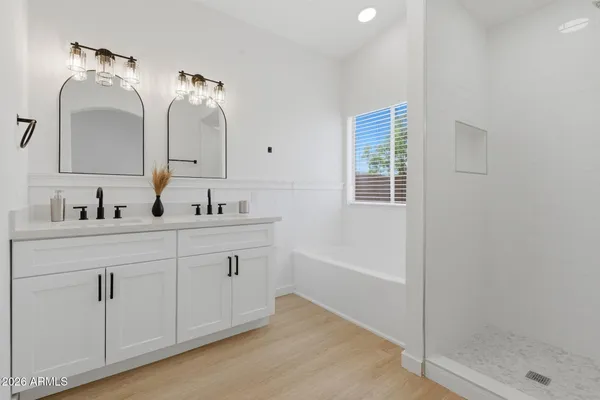 a bathroom with a double vanity sink mirror and shower