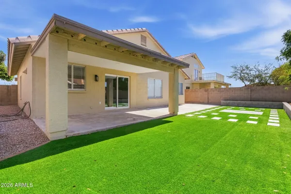 a view of a house with a small yard and a large tree