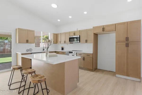 a kitchen with a sink a refrigerator and a stove top oven