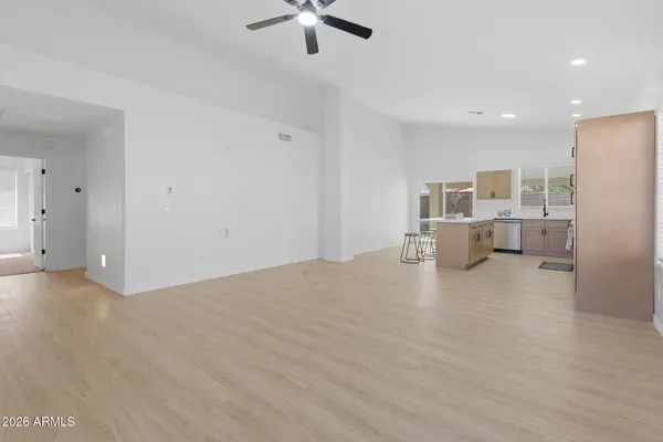 a view of empty room with kitchen and window
