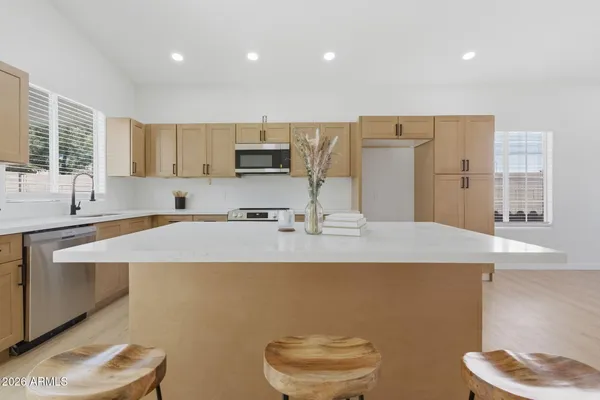 a kitchen with kitchen island a sink a stove and a refrigerator