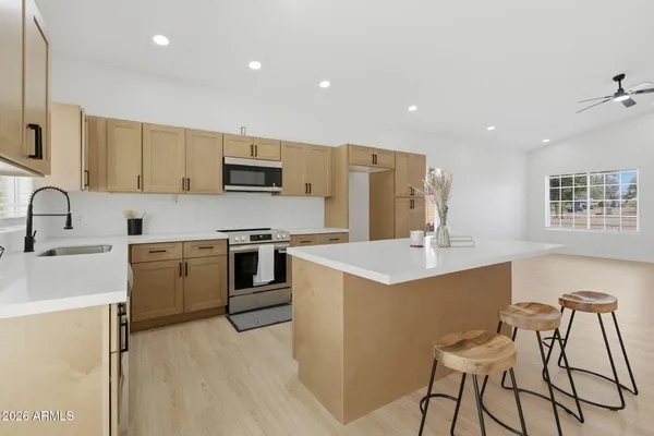 a kitchen with a stove a sink a microwave a counter top space and cabinets