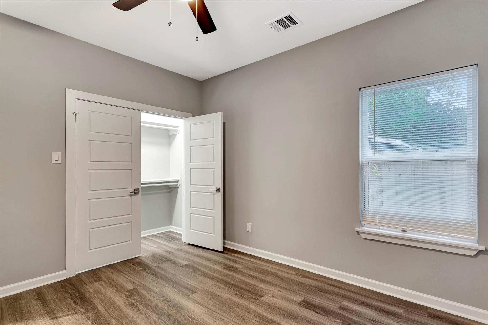 6813 Liverpool Street, Unit B Houston, TX 77021 - Photo 7 of 9 Bright room with ceiling fan and spacious walk-in closet with built-in shelving.