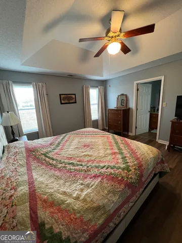 a bed sitting in a bedroom and a mirror in a bedroom