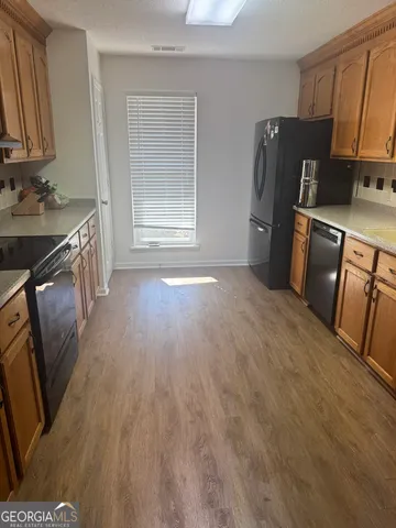 a kitchen with granite countertop a refrigerator stove and sink