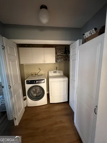 a utility room with wooden floor washer and dryer