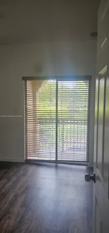 an empty room with floor to ceiling windows and closet