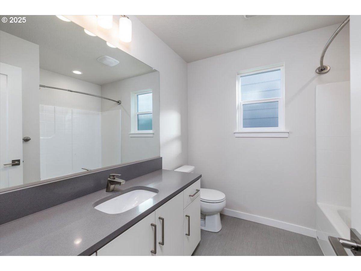 961 Southwest Stellar Terrace Beaverton, OR 97005 - Photo 20 of 25 a bathroom with a granite countertop double vanity sink a mirror and a toilet