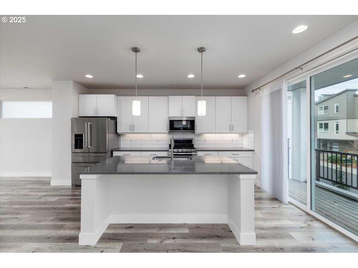 961 Southwest Stellar Terrace Beaverton, OR 97005 - Photo 10 of 25 a large kitchen with kitchen island a sink stainless steel appliances and cabinets