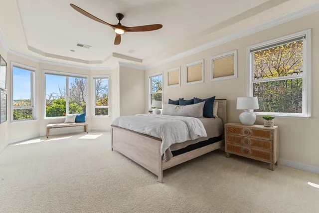 a bedroom with a bed a flat screen tv and a window