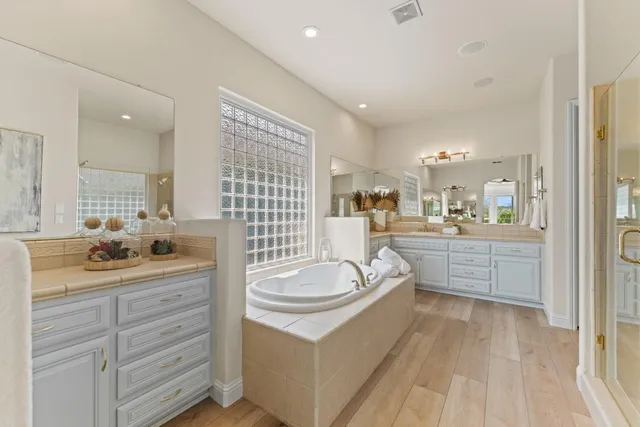 a spacious bathroom with a granite countertop sink a large mirror and a