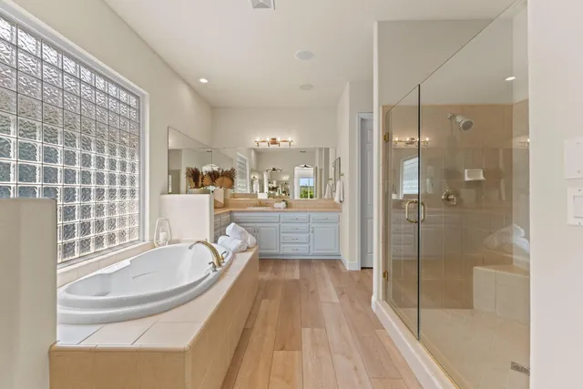 a bathroom with a granite countertop tub sink and mirror