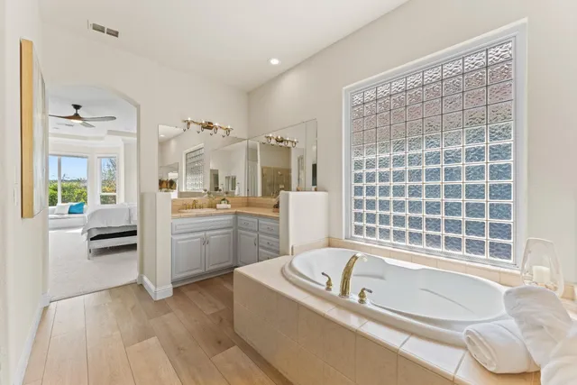 a dining room with wooden floor a chandelier a wooden table and chairs