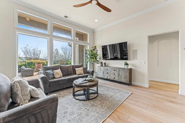 a living room with furniture a flat screen tv and a large window