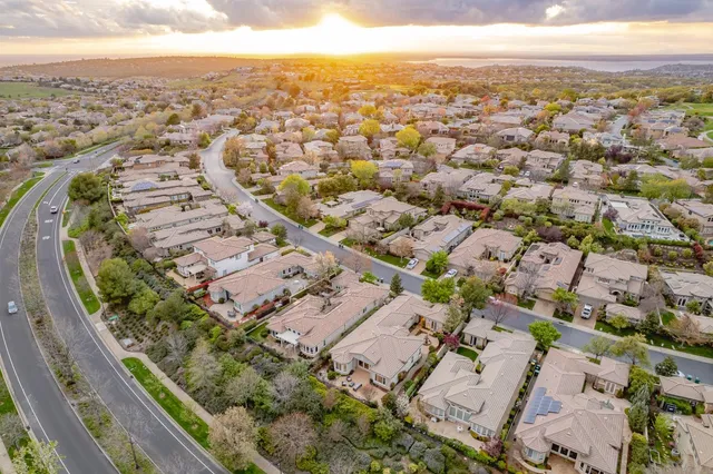 an aerial view of residential houses with outdoor space and swimming pool
