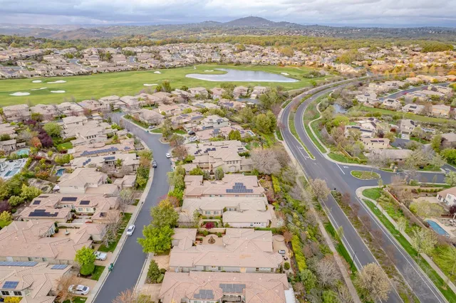 an aerial view of a house with a garden and lake view