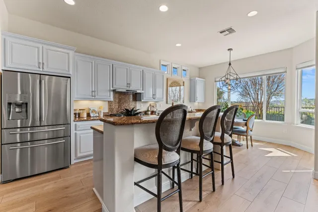 a kitchen with granite countertop a refrigerator and microwave