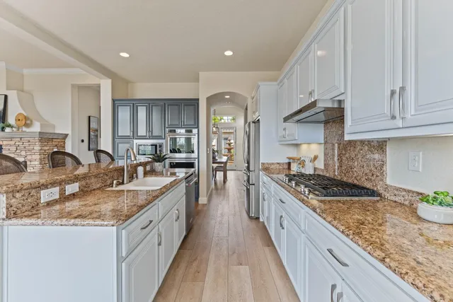 a large kitchen with granite countertop a sink and cabinets