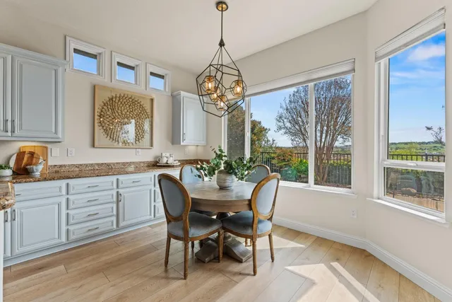 a view of a dining room with furniture a chandelier and wooden floor