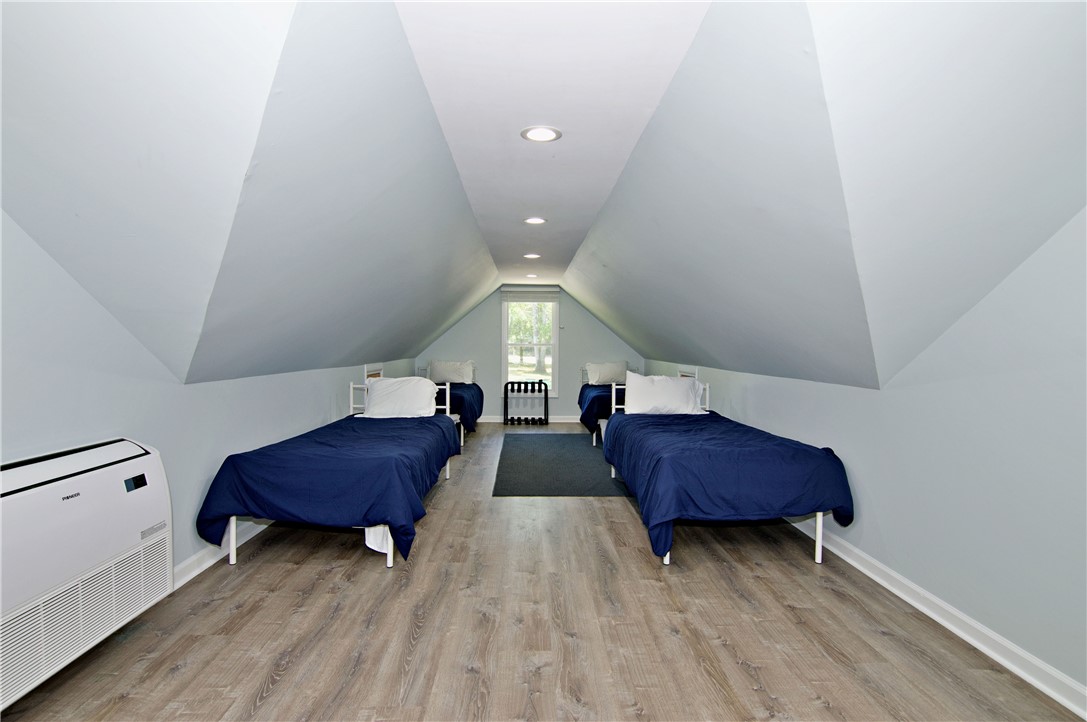 206 Petty Road Seneca, SC 29672 - Photo 24 of 49 Recessed lighting illuminates this upper-level bedroom featuring distinctive vaulted ceilings and wood-look flooring.