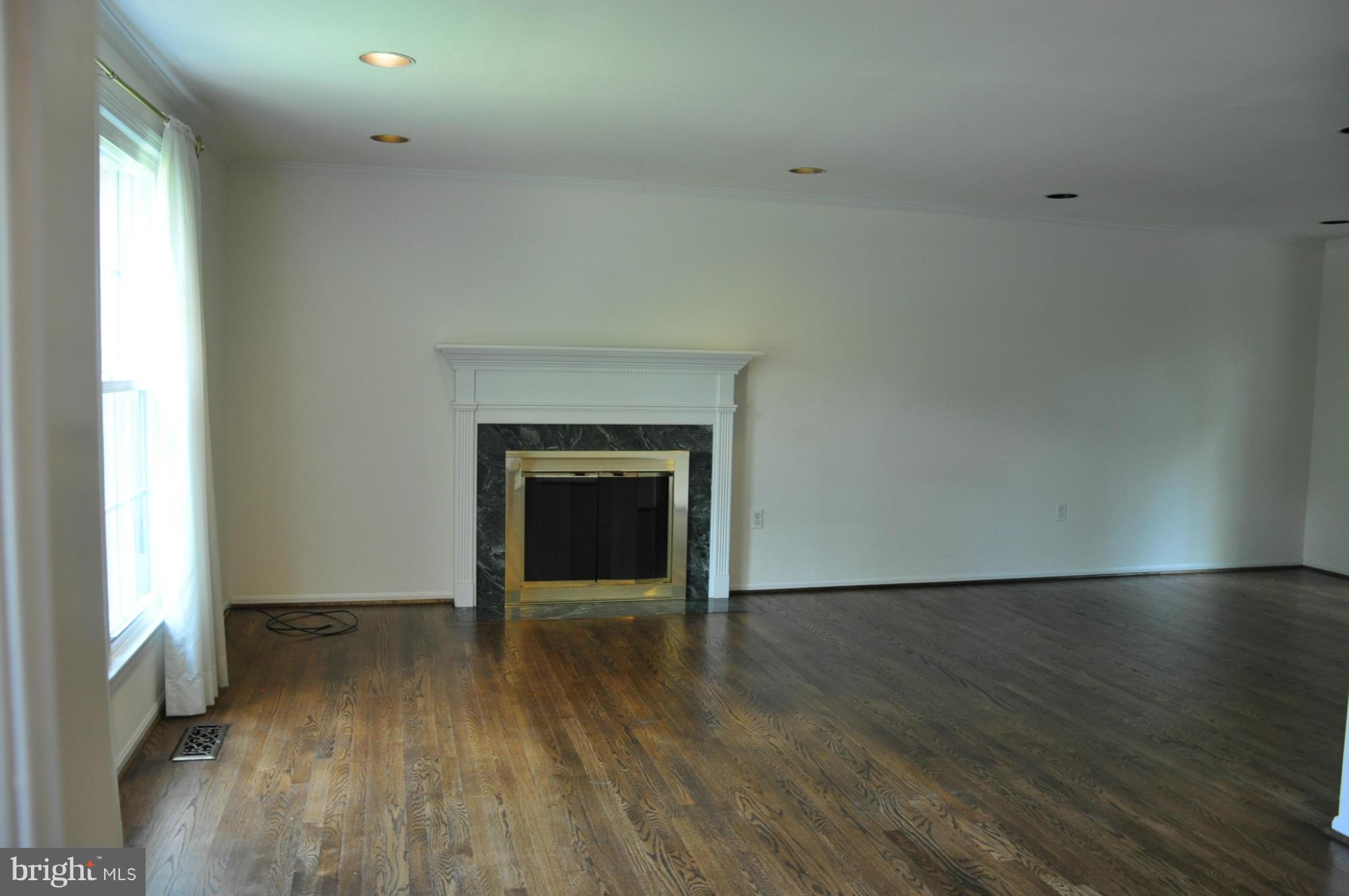 12 Starlight Court Potomac, MD 20854 - Photo 5 of 19 a view of empty room with wooden floor and fireplace