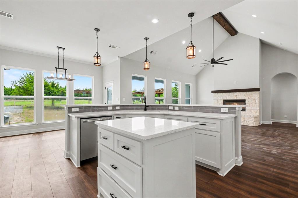 530 P R 491 Leonard, TX 75452 - Photo 13 of 35 Open-concept kitchen featuring an island with white cabinetry and a light-toned countertop, wood-finish flooring, and pendant lighting