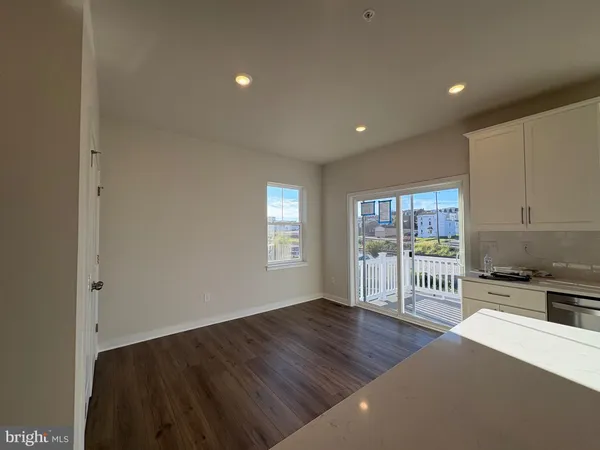 a view of empty room with wooden floor and fireplace