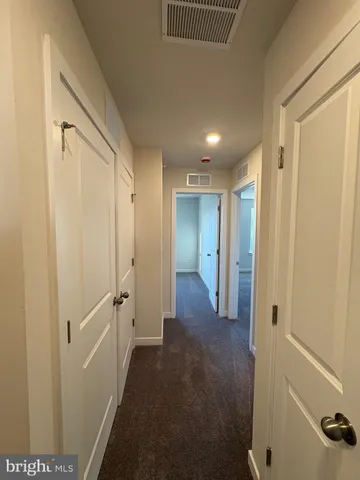 a view of a hallway with closet and wooden floor
