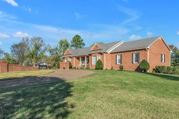 a front view of a house with a yard and trees