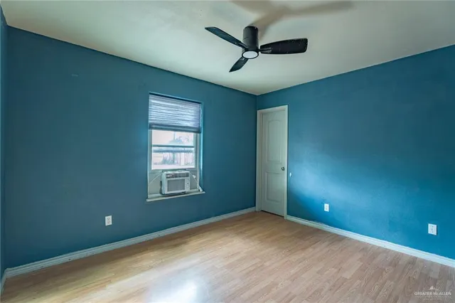 an empty room with windows and fan