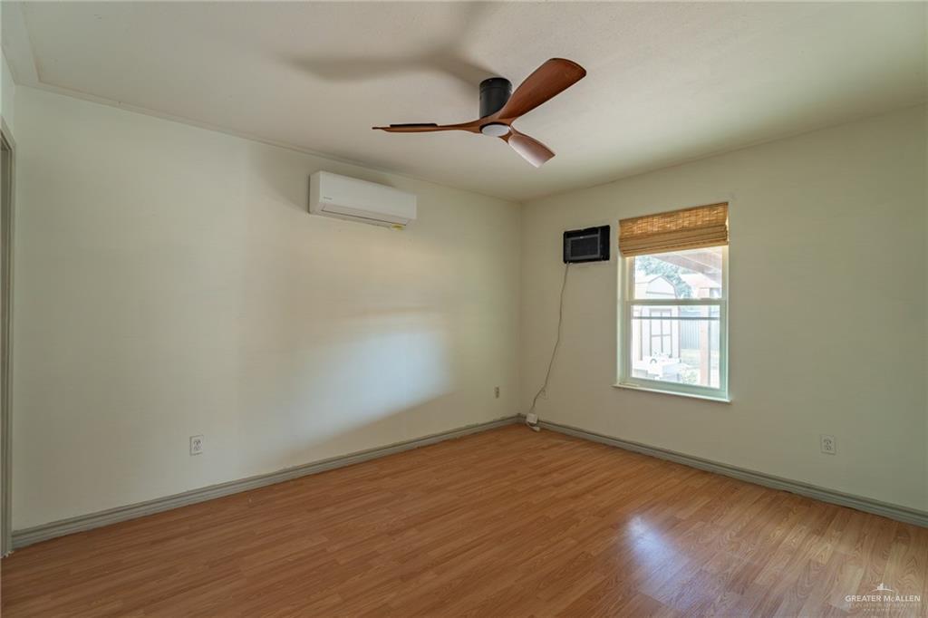 15002 Davis Road Edcouch, TX 78538 - Photo 16 of 33 an empty room with wooden floor ceiling fan and windows