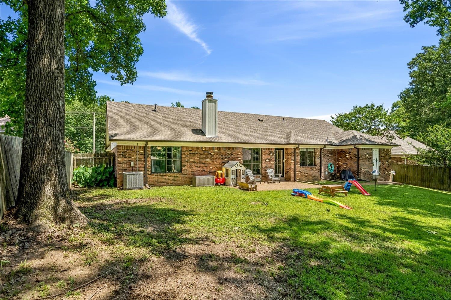 5711 Yale Road Bartlett, TN 38134 - Photo 25 of 29 Spacious backyard with a large patio, brick exterior, and mature tree