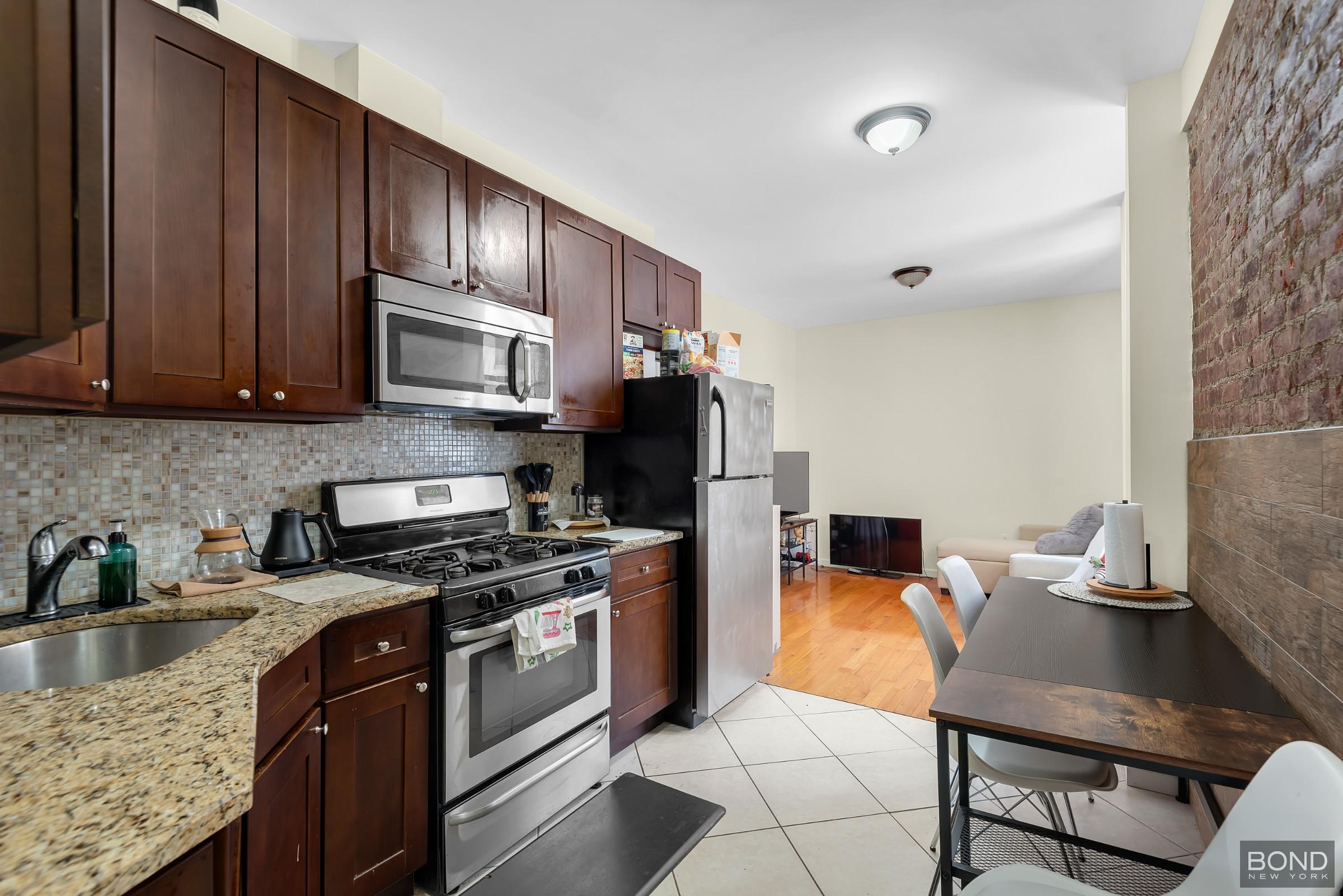 41-11 28th Avenue, Unit 1 Queens, NY 11103 - Photo 3 of 9 a kitchen with stainless steel appliances granite countertop a stove a sink a microwave a refrigerator and cabinets