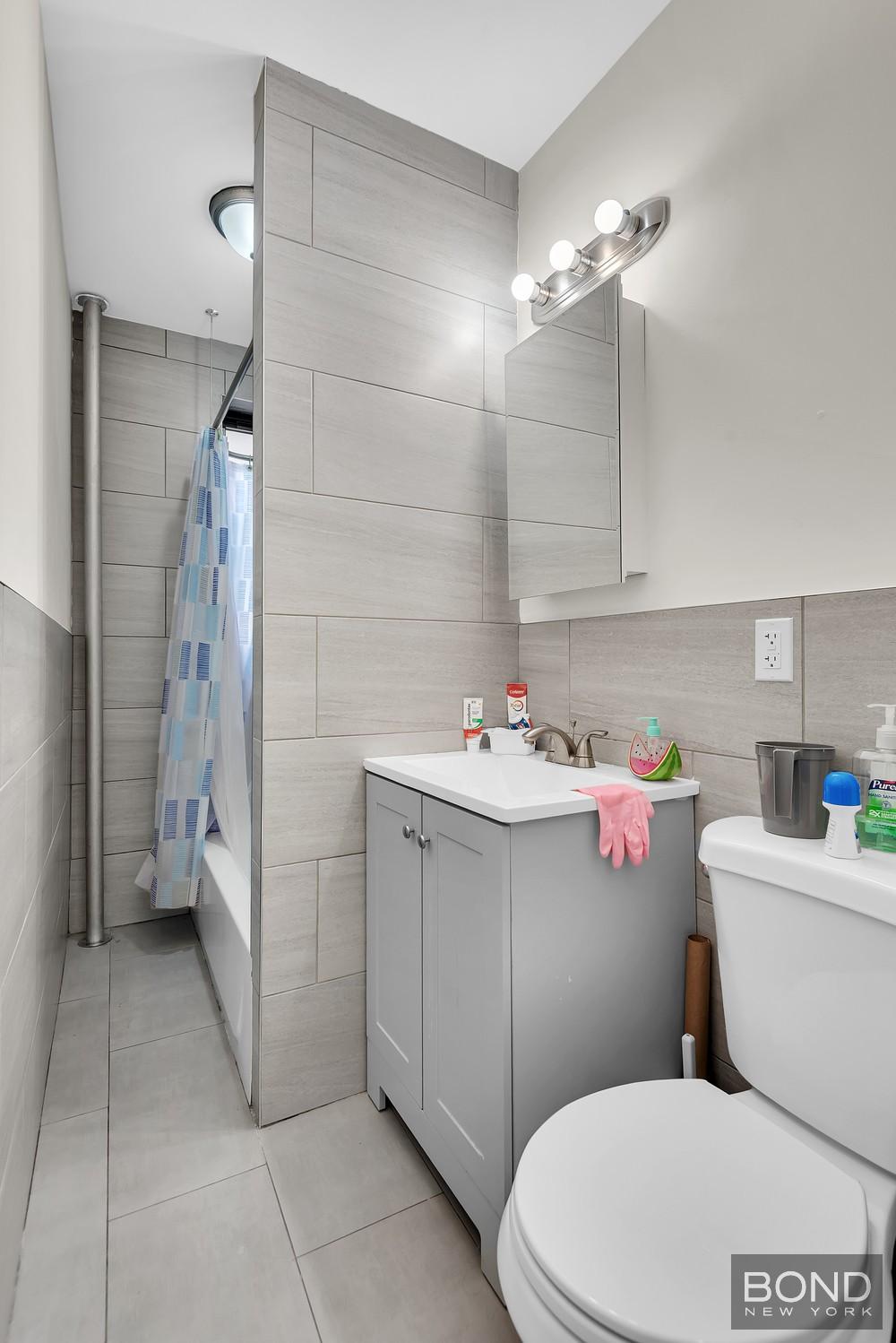 41-11 28th Avenue, Unit 1 Queens, NY 11103 - Photo 6 of 9 a bathroom with a sink a toilet and shower