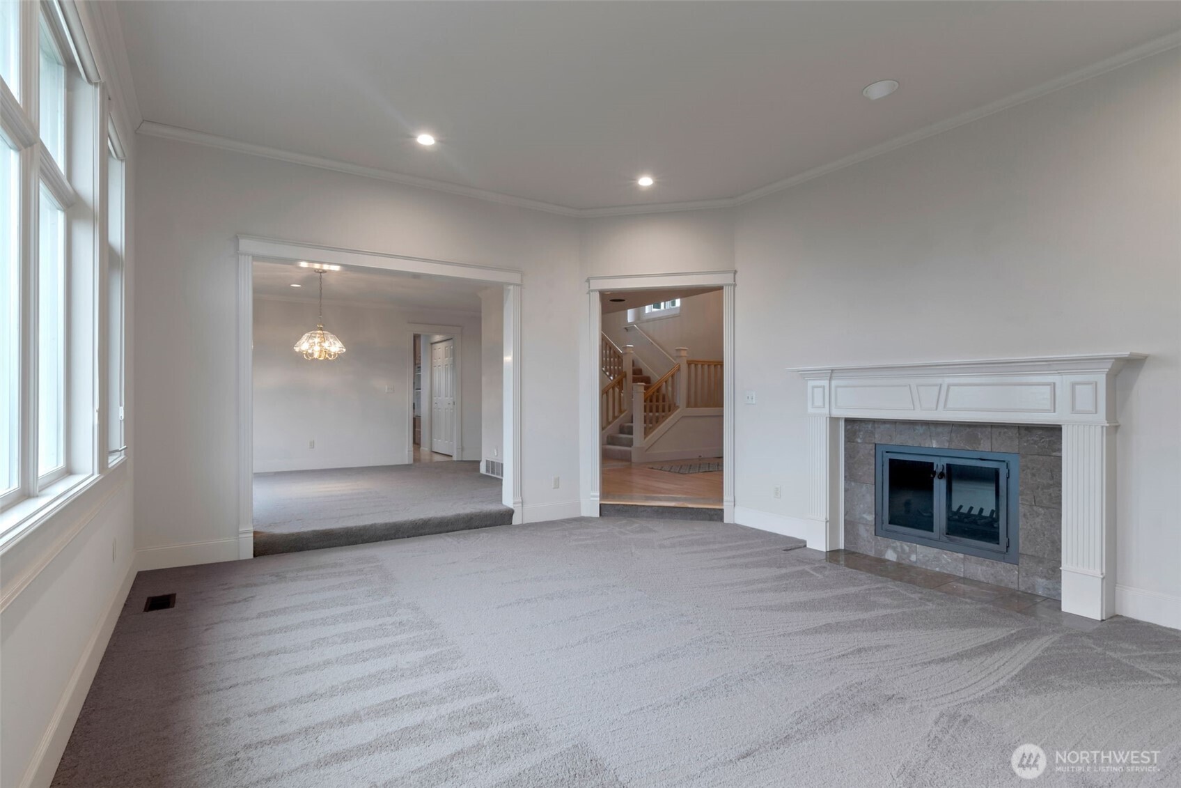 4131 205th Avenue Southeast Sammamish, WA 98075 - Photo 16 of 20 an empty room with wooden floor fireplace and windows