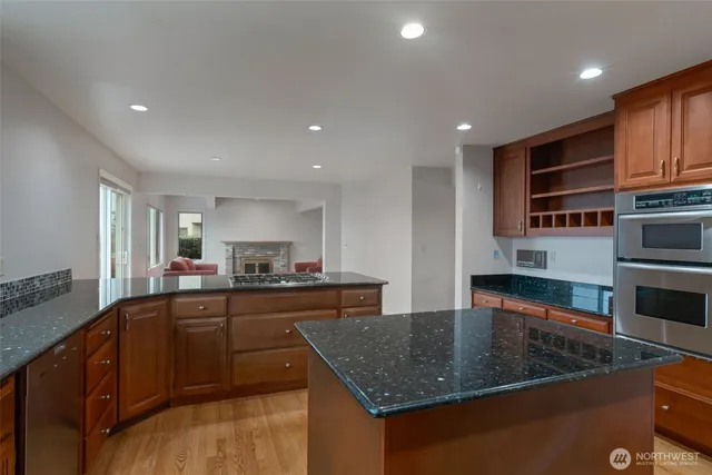 a kitchen with stainless steel appliances granite countertop a sink a stove and a refrigerator