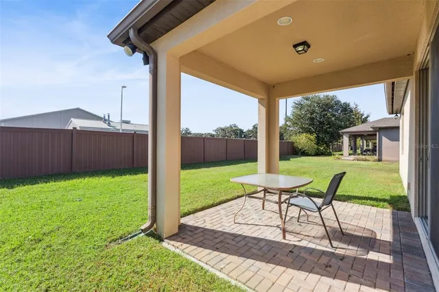 a view of a house with backyard and sitting area