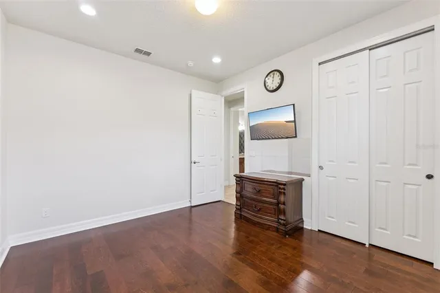 a view of an empty room with wooden floor