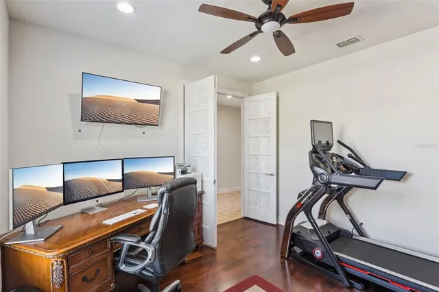 a room with furniture a ceiling fan and wooden floor