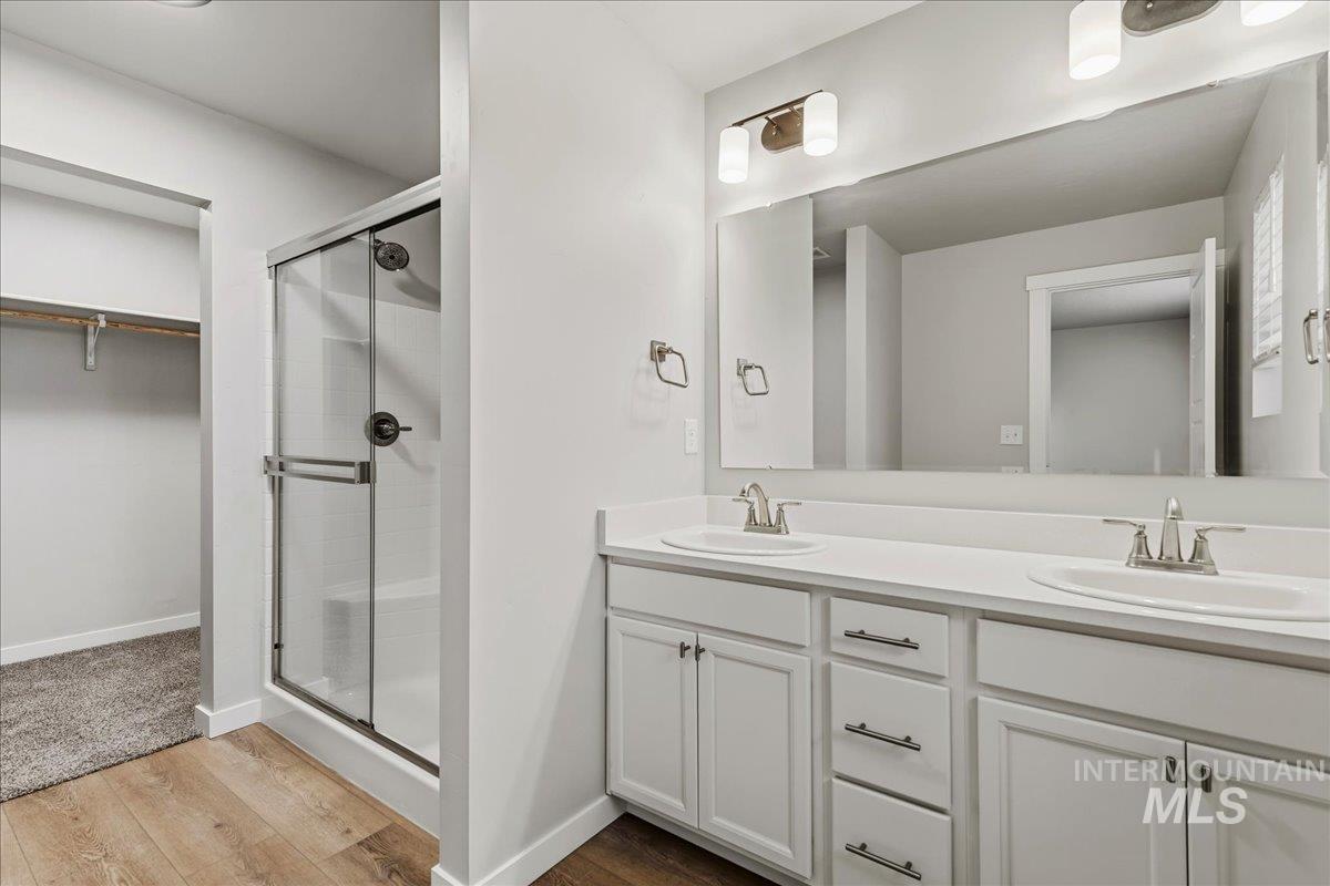 12475 West Victory Road Boise, ID 83709 - Photo 19 of 26 Bathroom featuring a dual vanity with white cabinetry, white countertops, and brushed nickel fixtures
