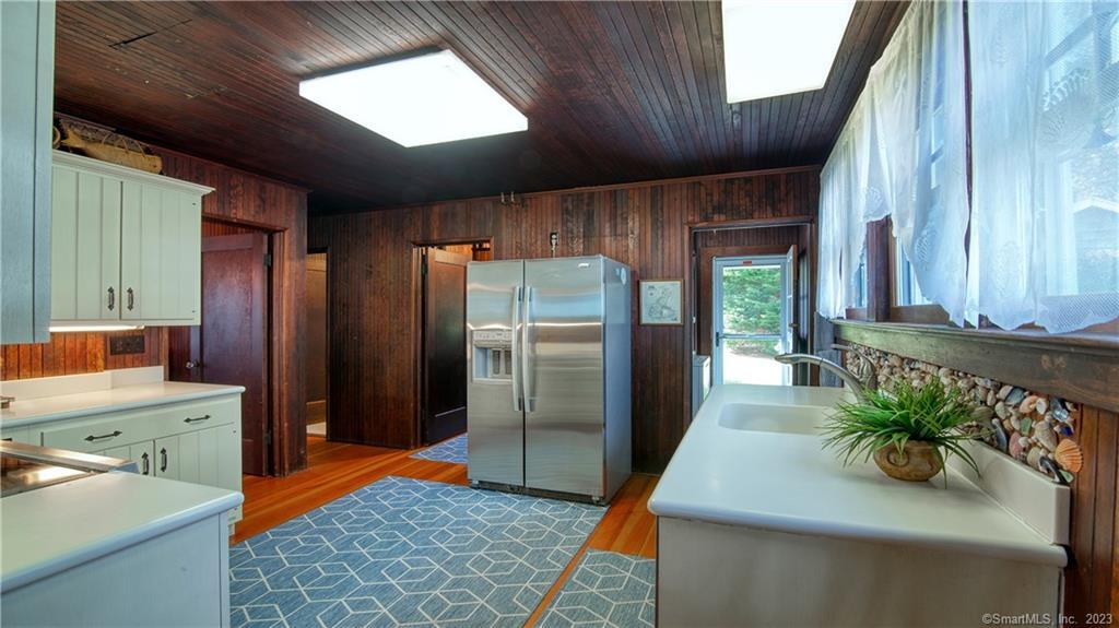 106 East Shore Avenue Groton, CT 06340 - Photo 17 of 39 a kitchen with stainless steel appliances kitchen island granite countertop a refrigerator a stove and a sink with large window
