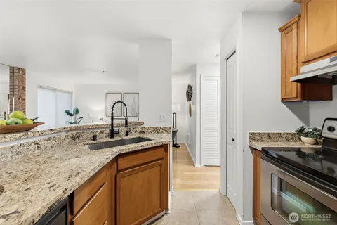 a kitchen with granite countertop a sink stainless steel appliances and cabinets